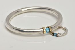 A SILVER AND TOPAZ BANGLE WITH MATCHING RING, a solid silver bangle with yellow metal accents,