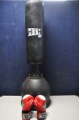 A FREESTANDING PUNCHING BAG with a water filled base bearing the name HTH along with a pair of red