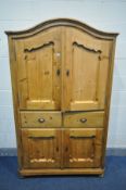 A PINE PANELLED TWO DOOR CABINET, with an arched top, two drawers above double cupboard doors, width