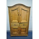 A PINE PANELLED TWO DOOR CABINET, with an arched top, two drawers above double cupboard doors, width