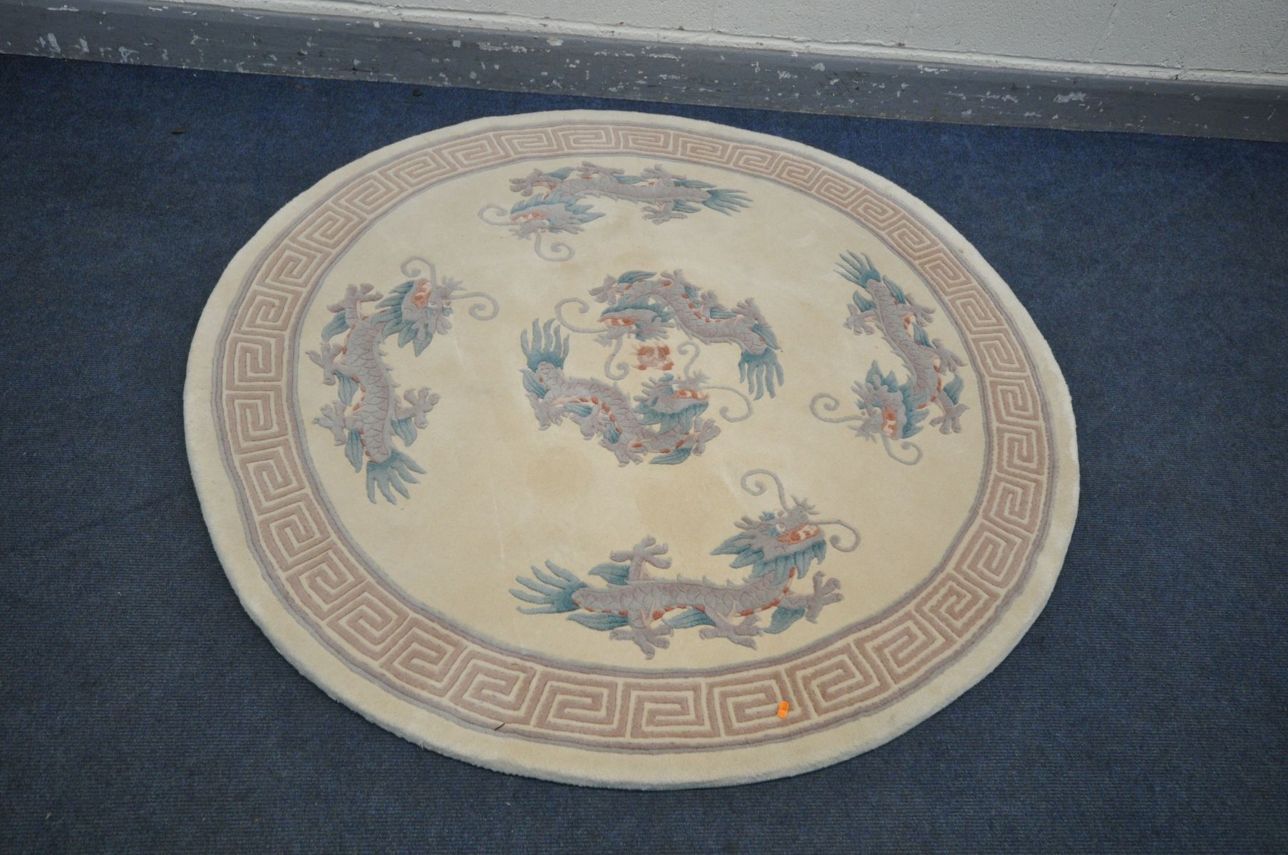 A CIRCULAR CREAM CHINESE RUG, with a dragon pattern, diameter 155cm