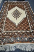 A BROWN AND CREAM GEOMETRIC WOOLLEN RUG, 322cm x 198cm and a similar smaller rug, 283cm x 194cm (2)