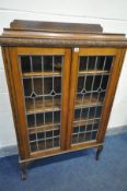 AN EARLY 20TH CENTURY OAK LEAD GLAZED TWO DOOR BOOKCASE, with three adjustable shelves, width 91cm x