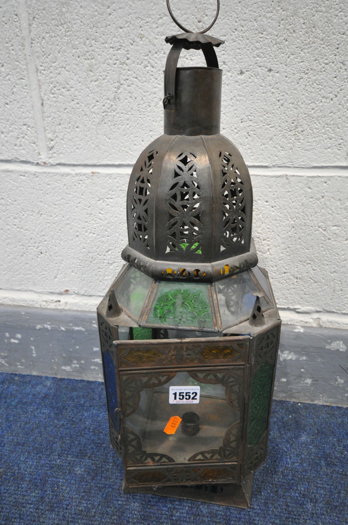 A 20TH CENTURY PRESSED METAL MOROCCAN HANGING LANTERN, with coloured glass panels, 20cm squared x