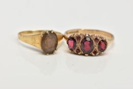 A 9CT GOLD GARNET RING AND A YELLOW METAL SMOKEY QUARTZ RING, the first ring designed with three