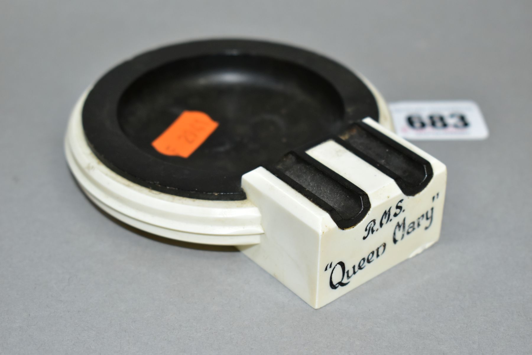 AN ART DECO BAKELITE RMS QUEEN MARY ASHTRAY, in cream and black, with RMS Queen Mary marked on one