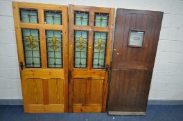 TWO STAINED PITCH PINE DOORS, with Flour De Lis lead glazed panels, 94cm x 197, 76cm x 199cm (