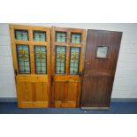 TWO STAINED PITCH PINE DOORS, with Flour De Lis lead glazed panels, 94cm x 197, 76cm x 199cm (