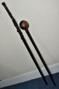 AN AFRICAN CARVED HARDWOOD WALKING STICK AND A LIGNUM VITAE KNOB KERRIE, the walking stick carved