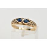 A 9CT GOLD SAPPHIRE AND DIAMOND RING, set with two pear cut blue sapphires, each collet mounted,