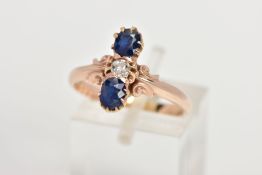 A SAPPHIRE AND DIAMOND RING, two oval cut blue sapphires atop and beneath a round brilliant cut