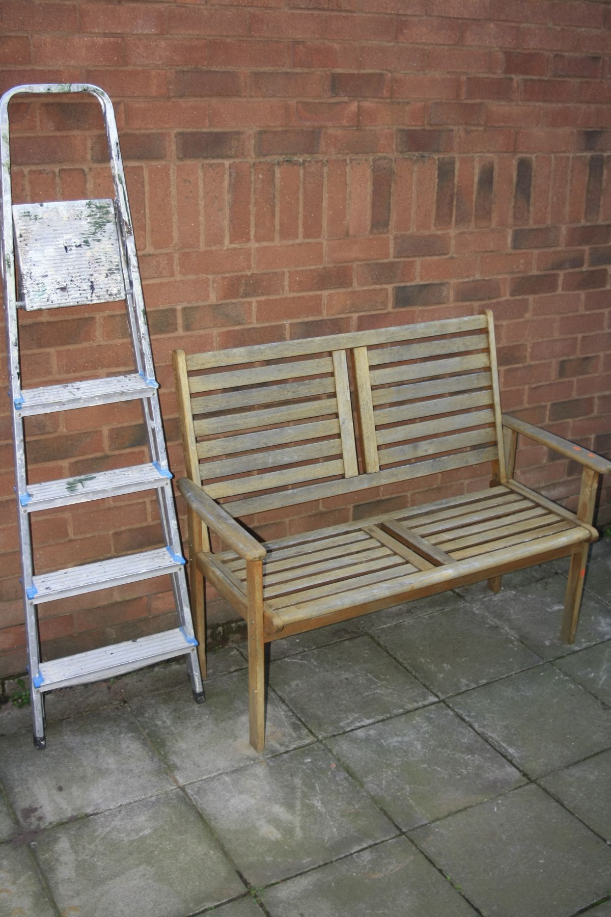 A TEAK GARDEN BENCH, width 120cm x depth 57cm x height 95cm together with a set of step ladders,