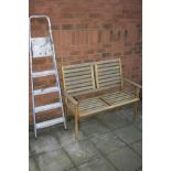 A TEAK GARDEN BENCH, width 120cm x depth 57cm x height 95cm together with a set of step ladders,