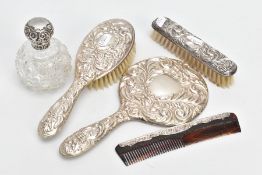 SILVER VANITY ITEMS, to include a mirror and two hair brushes, with foliage detailing and a vacant