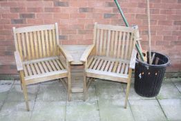 A TEAK CURVED SIDE BY SIDE GARDEN SEATING UNIT with two shelves and a parasol holder to centre