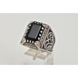 A GENTLEMENS LARGE WHITE METAL SIGNET RING, set with a rectangular cut black stone, within a Greek