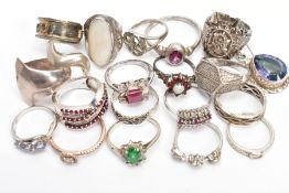 A PARCEL OF SILVER AND WHITE METAL RINGS, to include a silver diamond and ruby set crossover style