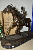 A BRONZE SCULPTURE OF A RACE HORSE AND JOCKEY, a galloping horse with mounted jockey on a stone