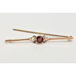 AN EARLY 20TH CENTURY, 15CT GOLD BAR BROOCH, set with a circular cut garnet, collet mounted,