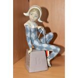 A LLADRO FIGURINE HARLEQUIN B, NO.5076, depicting a harlequin boy seated on a block impressed with