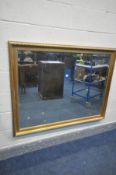 A LARGE GILT FRAMED BEVELLED EDGE WALL MIRROR, 139cm x 106cm (condition:-paint splatters to frame)