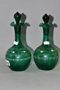 A PAIR OF VICTORIAN GREEN GLASS DECANTERS, with stoppers and four bands of dotted floral and other