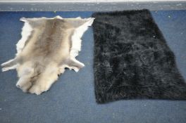 A HANLIN LTD REINDEEER HIDE RUG, 134cm x 116cm and a black bed throw (2)