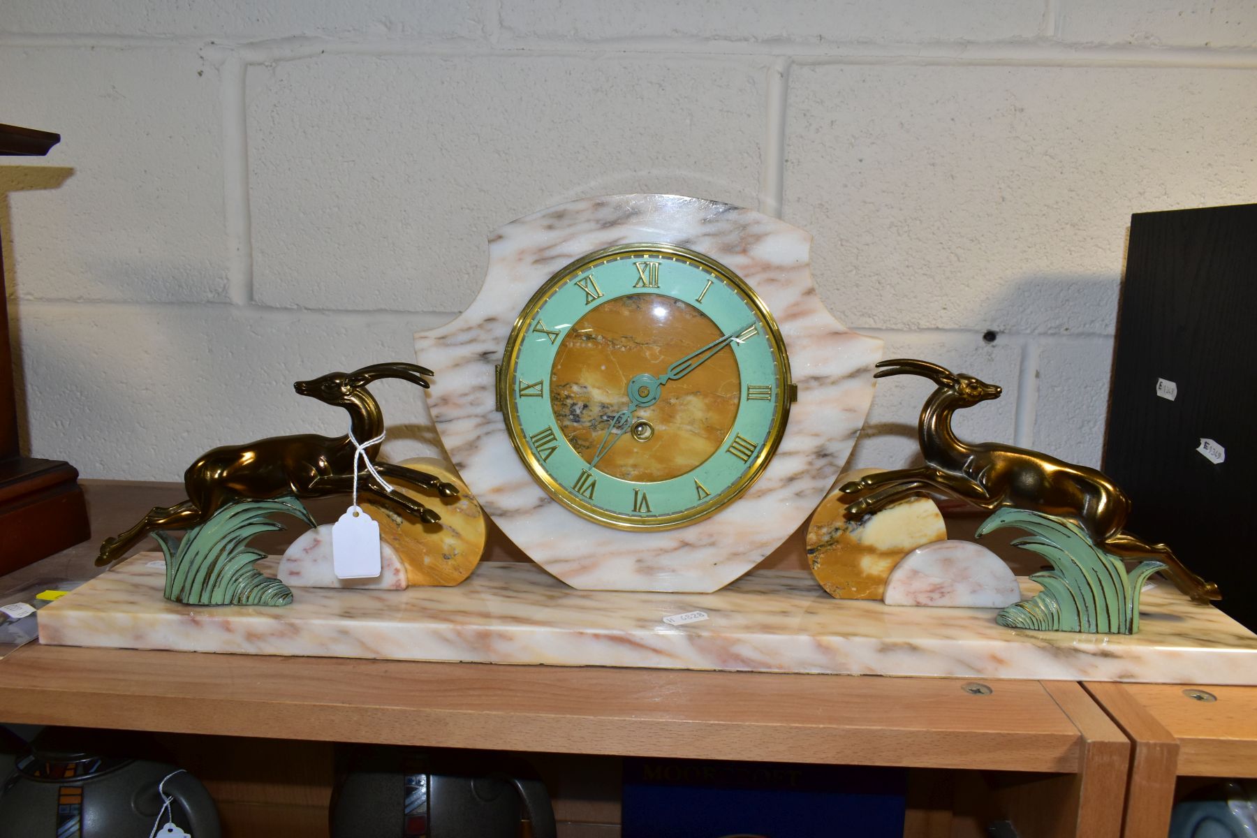 AN ART DECO STYLE CLOCK, shield shaped, Roman numerals, flanked by two leaping deer, height 24.5cm x