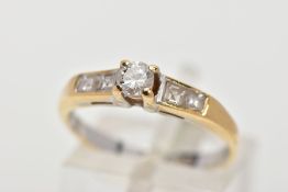 A DIAMOND RING, designed with a central brilliant cut diamond in a four claw setting, flanked by two