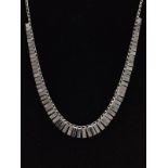 A WHITE METAL COLLAR STYLE NECKLACE, featuring a graduated fringe, with intermittent bark effect and