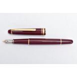 A MONTBLANC FOUNTAIN PEN, burgundy lacquer with gold detailing, signed 'Montblanc-Meisterstuck'