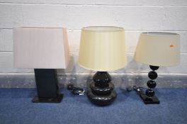 THREE VARIOUS BLACK FINISH TABLE LAMPS, of various styles and materials