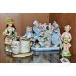 A GROUP OF FOUR 19TH AND 20TH CENTURY PORCELAIN FIGURES, comprising a figure of a putti with