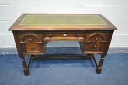 AN REPRODUCTION OAK OLD CHARM STYLE LADIES DESK, with a green leather tooled inlay, a central drawer