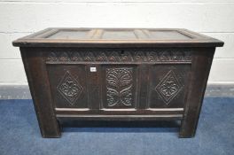 A GEORGIAN OAK COFFER, with triple carved front panels, on later fitted casters, width 109cm x depth