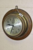 A MID 20TH CENTURY BRASS SHIP STYLE CLOCK, MOUNTED TO AN OAK BOARD, the circular dial having