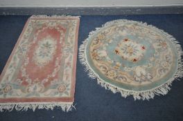 A CIRCULAR GREEN CHINESE WOOLLEN RUG, diameter 125cm and a pink Chinese rug (2)