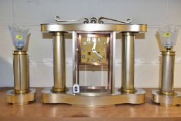 AN ART DECO STYLE CLOCK GARNITURE, the gold coloured metal case with chromed details, Arabic