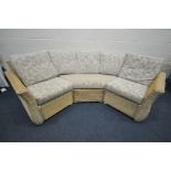 A LIGHT WICKER ROUNDED CONSERVATORY SOFA, with floral cushions, breaks into three sections