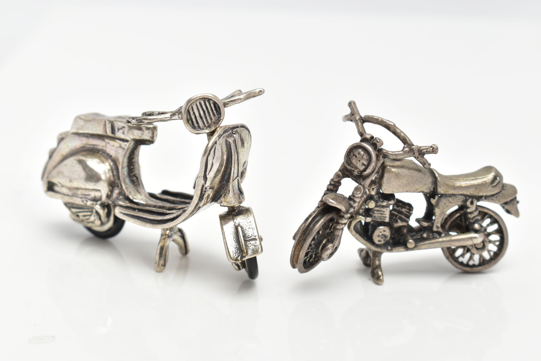 TWO WHITE METAL MINIATURE MOTORCYCLE FIGURINES, one with very rubbed stamps, the other unmarked