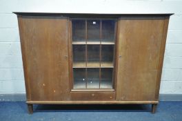 AN EARLY 20TH CENTURY OAK TRIPLE DOOR BOOKCASE, the outer two doors with shelving and three drawers,