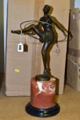 A REPRODUCTION BRONZE ART DECO STYLE FIGURE OF A DANCER WITH A HOOP, standing on a marble style