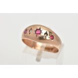 AN EARLY 20TH CENTURY 9CT GOLD GYSPY RING, designed with three star set, circular cut red stones the