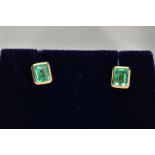 A PAIR OF EMERALD EARRINGS, emerald cut emeralds approximate size 5mm x 4mm, bezel set in a closed