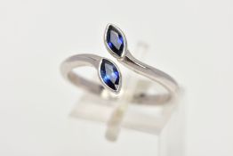 AN 18CT WHITE GOLD SAPPHIRE RING, of a cross over design, set with two marquise cut blue sapphires