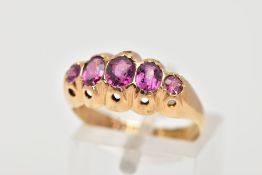 AN EARLY 20TH CENTURY AMETHYST RING, set with three oval cut amethysts and two circular cut