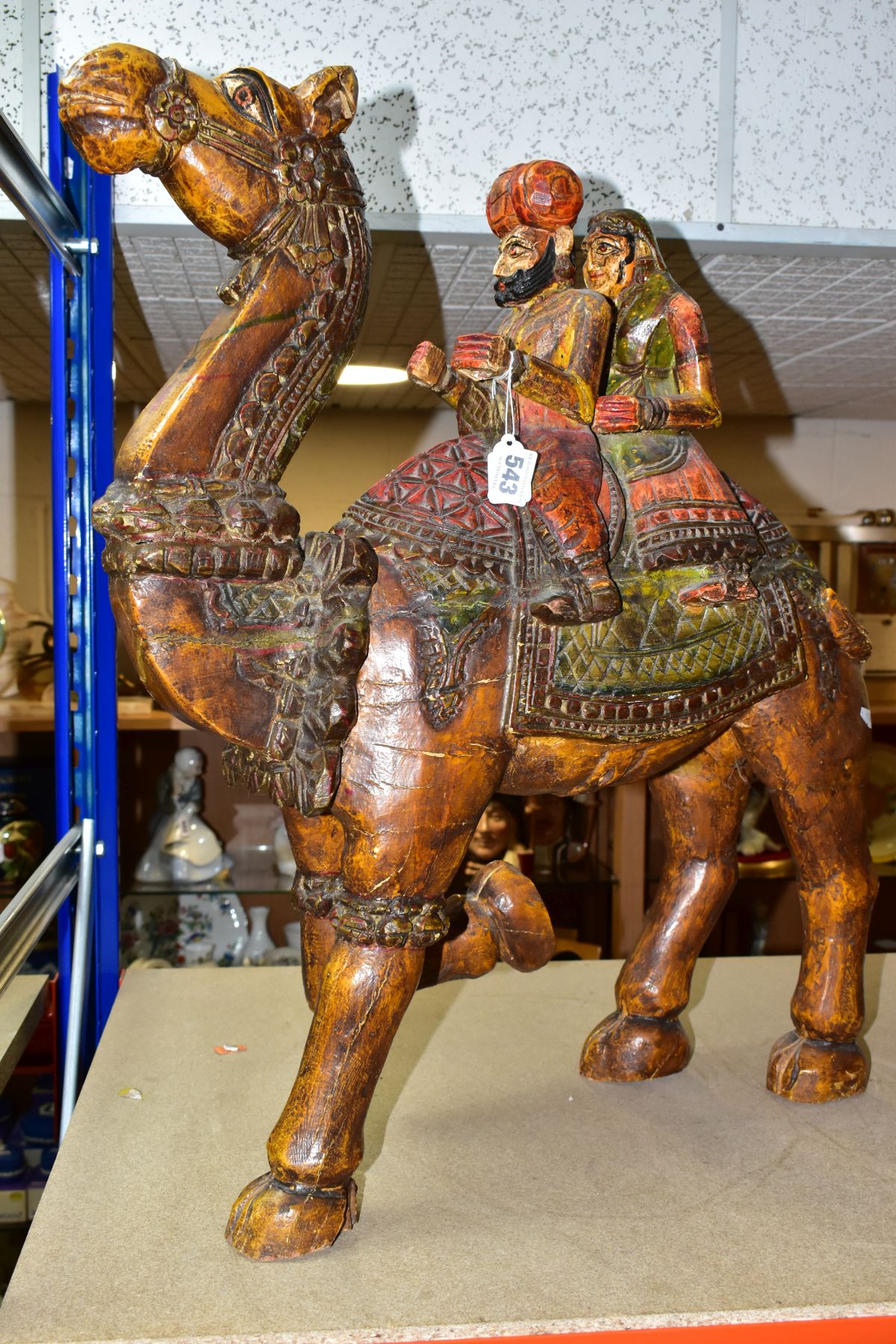 A LARGE WOODEN CARVED CAMEL WITH RIDERS, with carved and painted details, it may depict the