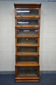 AN EARLY 20TH CENTURY OAK SEVEN PIECE SECTIONAL BOOKCASE, with hide and fall glass doors, width 87cm