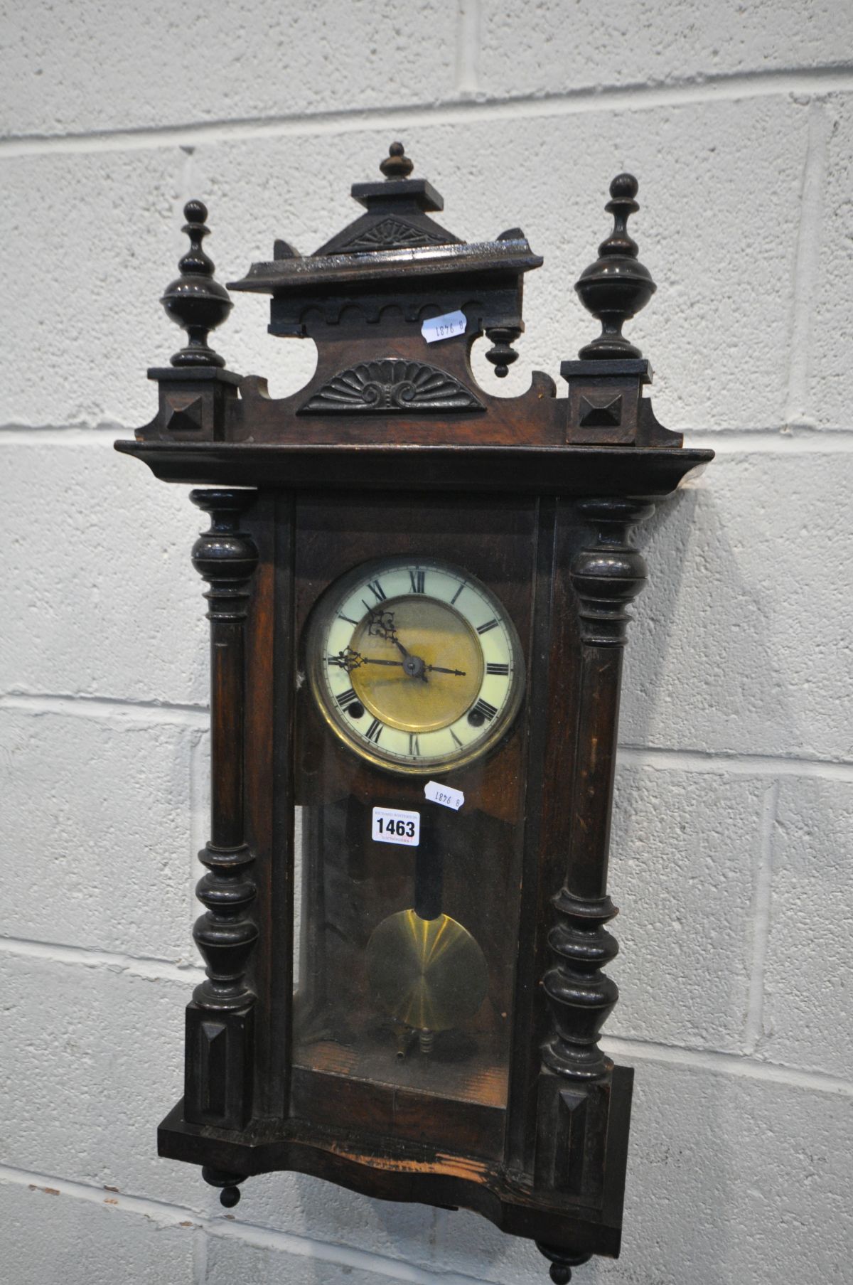 A MAHOGANY VIENNA WALL CLOCK, with pendulum and two winding keys (condition:-one broken finial)