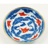 A Chinese porcelain small dish, 19th century, painted in underglaze blue with iron-red bats flying
